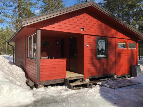 a red cabin with a porch in the snow at Rena Hostel IVAR in Rena