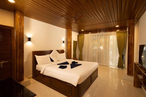 a bedroom with a large bed and a television at Crystall Goa Emerald Edition in Patnem