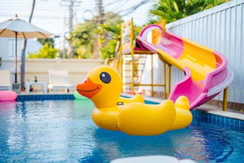 un canard en caoutchouc jaune dans une piscine avec toboggan dans l'établissement ไอทะเล พูลล่า หัวหิน I-Talay Poolvilla huahin, à Hua Hin