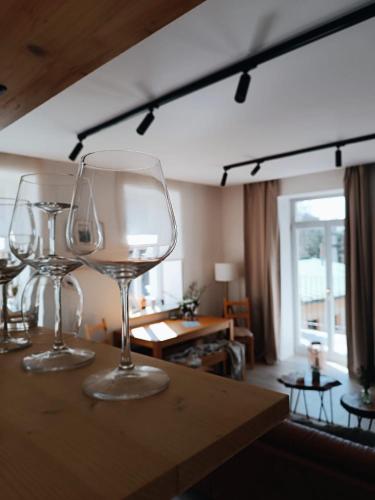 three wine glasses sitting on top of a table at Apartmán u starého pivovaru in Rudník