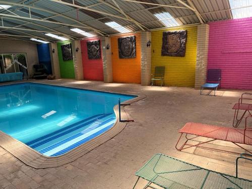 a large swimming pool in a room with colorful walls at Dula Monate Holiday Flats in Bela-Bela