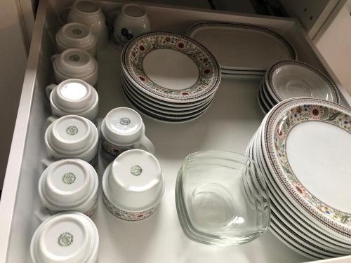 un cassetto pieno di piatti e piatti e uno specchio di Rena Hostel IVAR a Rena