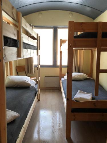 two bunk beds in a room with a window at Rena Hostel IVAR in Rena