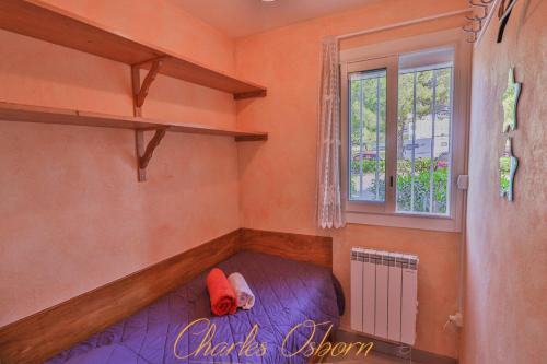 een kleine kamer met een bed en een raam bij Le "Pépère" charming apartment 150m from the beach in Sète