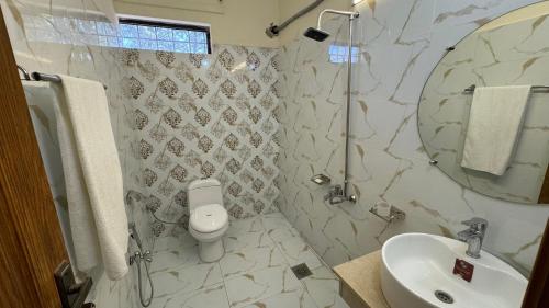 a bathroom with a toilet and a sink and a shower at Orbit Royal in Islamabad