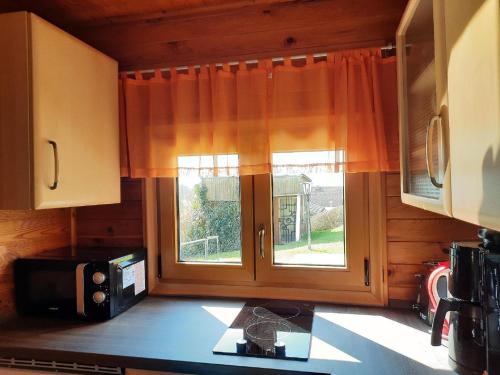 a kitchen with a window on the counter with a microwave at Ferienhaus Keller in Freyung