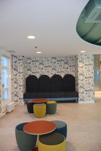 a room with a couch and tables and chairs at Loop INN Hostel Santiago de Compostela in Santiago de Compostela