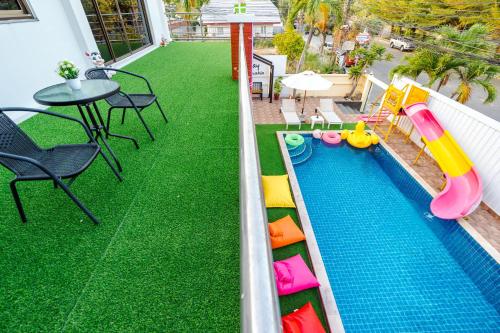 a backyard with a pool with a slide and a table at ไอทะเล พูลล่า หัวหิน I-Talay Poolvilla huahin in Hua Hin