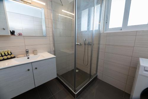 y baño con ducha y lavamanos. en Drapetsona Modern Living (DRAP_C2), en Pireo