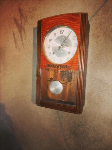 um relógio de madeira está pendurado na parede em Ranger's Cottage em Ambawela