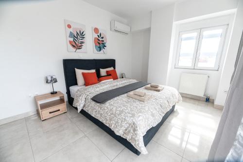 1 dormitorio con 1 cama grande con almohadas de color naranja en Drapetsona Modern Living (DRAP_C2), en Pireo