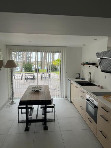 a kitchen with a table in the middle of it at La Villa Bel Ange Hotel in Saint-Philibert