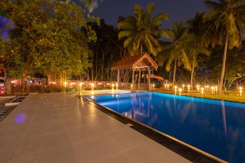 una piscina notturna con gazebo di Elysia Sigiriya Hotel a Dambulla