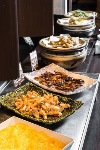 a buffet with plates of food on a table at Via Inn Prime Kyotoeki Hachijoguchi in Kyoto