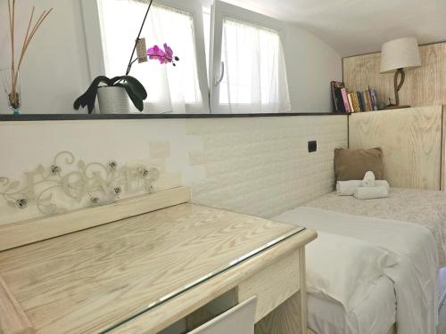 een kamer met een bed, een tafel en een spiegel bij LA Giulia in Capri