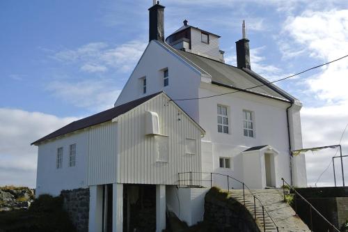 een wit gebouw met een toren erop bij Lofoten Fyr in Værøy