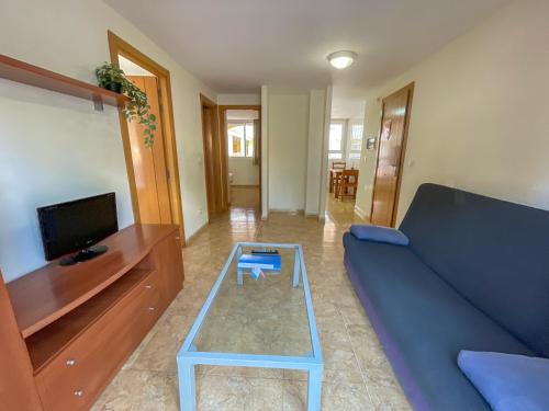 a living room with a blue couch and a coffee table at Apartamentos Gardenias 3000 in Alcossebre