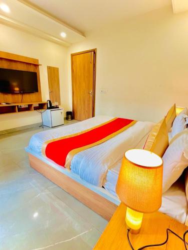 una camera da letto con un grande letto con una coperta rossa e gialla di Amahi Inn - Sector 48 a Gurgaon