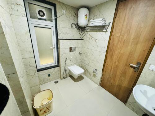 a bathroom with a toilet and a sink at Amahi Inn - Sector 48 in Gurgaon