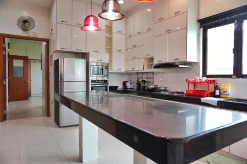 a large kitchen with white cabinets and a large counter top at 40P, Subang Villa with Pool/BBQ/Karaoke/Meeting in Subang Jaya