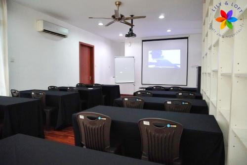 a conference room with tables and chairs and a screen at 40P, Subang Villa with Pool/BBQ/Karaoke/Meeting in Subang Jaya