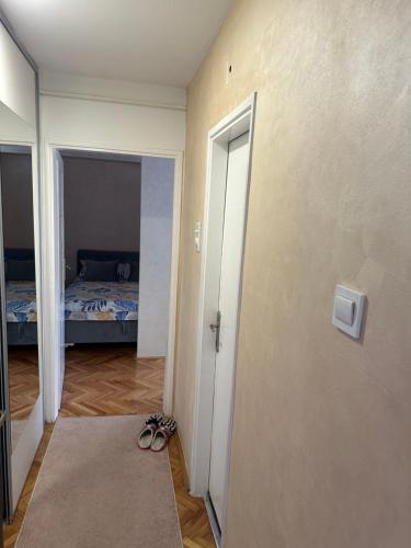 a room with a bedroom with a bed and shoes at Apartman Nira in Zenica