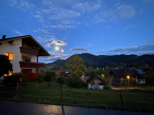 a house with a view of a mountain at dusk at Ferienwohnung Haslach in Wertach