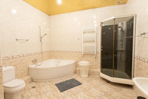 ein Badezimmer mit einer Badewanne, einem WC und einem Waschbecken in der Unterkunft Suite Penthouse 55 in Tbilisi City