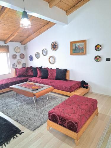 a living room with a red couch and a table at The house of dreams in Shkodër