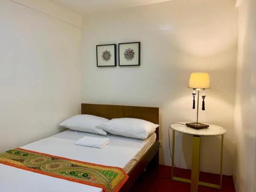 マニラにあるCourtyard Hotelのベッドルーム1室(ベッド1台、テーブルの上にランプ付)