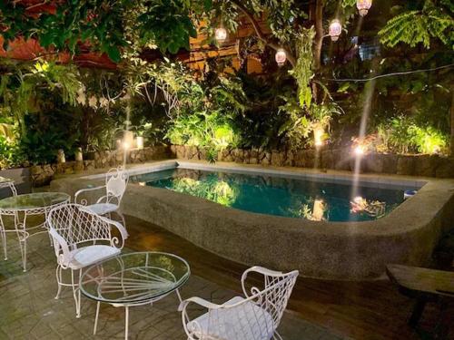 una piscina con mesas y sillas, una mesa y una mesa y sillas en Courtyard Hotel, en Manila