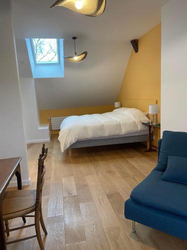une chambre avec un lit, une table et une chaise dans l'établissement Les logis du Parc, à Bullion