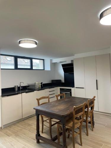 une cuisine avec une table et des chaises en bois dans l'établissement Les logis du Parc, à Bullion