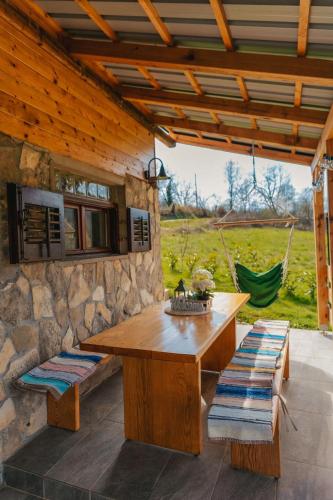 a wooden table and benches on a patio at River house "Green butterfly" in Netretić