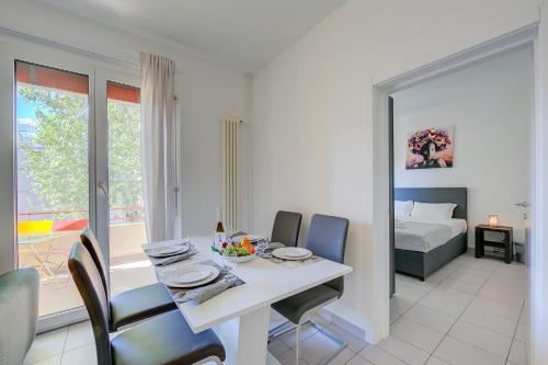 a dining room with a table and chairs and a bedroom at Casa Palma - Happy Rentals in Lugano