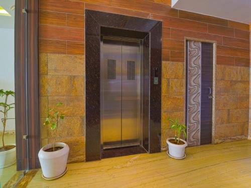 three potted plants sitting in front of an elevator at Hotel Harku Villa in Dabok