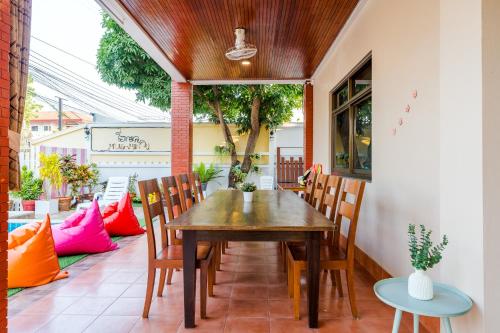 Une table et des chaises en bois sont disponibles sur la terrasse. dans l'établissement ไอทะเล พูลล่า หัวหิน I-Talay Poolvilla huahin, à Hua Hin