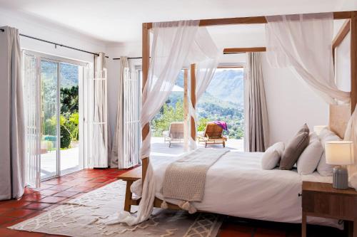 sypialnia z łóżkiem i dużym oknem w obiekcie Mountain View Villa w Kapsztadzie
