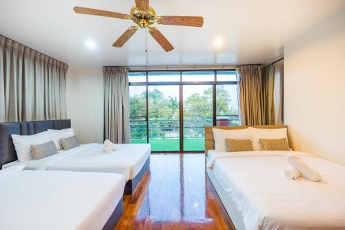 a bedroom with two beds and a ceiling fan at ไอทะเล พูลล่า หัวหิน I-Talay Poolvilla huahin in Hua Hin