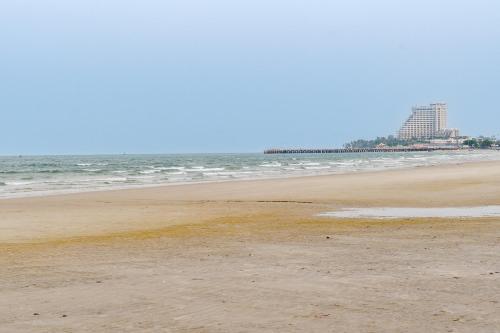 a beach with the ocean and a building in the background at ไอทะเล พูลล่า หัวหิน I-Talay Poolvilla huahin in Hua Hin
