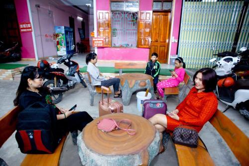 a group of people sitting in a room with motorcycles at Nhà Nghỉ Khánh Linh in Ha Giang