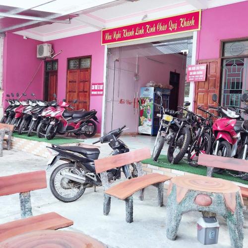 a group of motorcycles parked in front of a pink building at Nhà Nghỉ Khánh Linh in Ha Giang