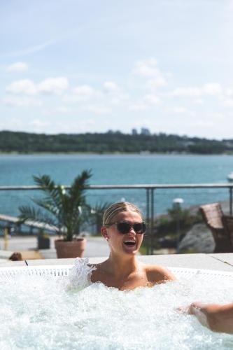 a woman is sitting in a jacuzzi at Stenungsbaden Yacht Club in Stenungsund