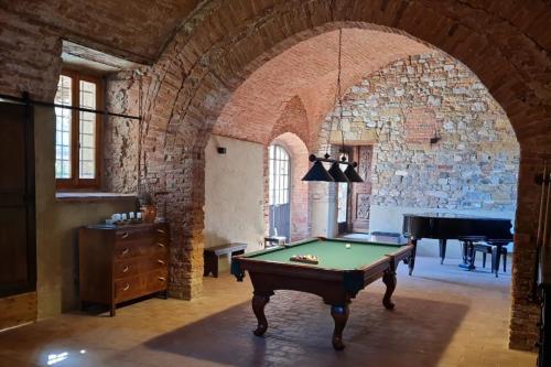 Habitación con mesa de billar y piano en Abbadia Sicille Relais, en Trequanda