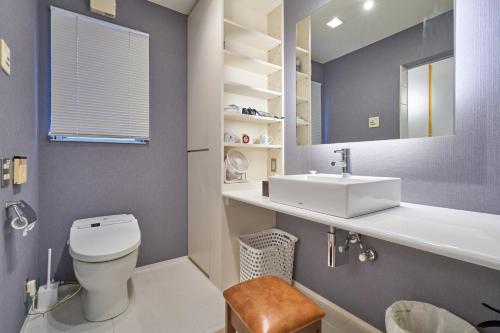 La salle de bains est pourvue de toilettes blanches et d'un lavabo. dans l'établissement Morden stylish villa/120㎡/Max12p/Free wifi, à Tokyo