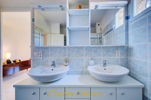 ein Badezimmer mit 2 Waschbecken und einem Spiegel in der Unterkunft Stoneview Villa in Sète