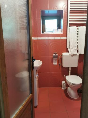 a red bathroom with a toilet and a sink at Arsenal Park Transilvania in Orăştie