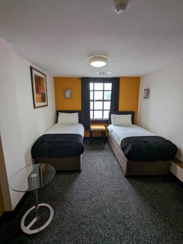a hotel room with two beds and a table at Cornmill Hotel in Hull