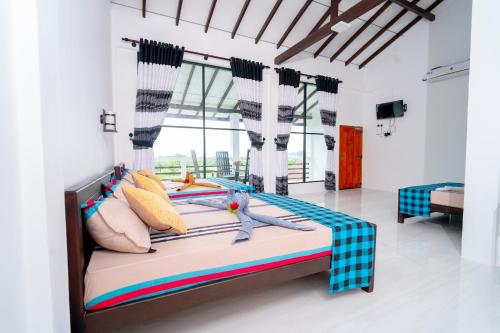 a bedroom with a large bed in a room at Passi Nature Villas Pasikuda in Kalkudah