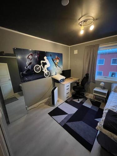 Habitación con 1 dormitorio con escritorio y ordenador. en Narvik sentrum en Narvik
